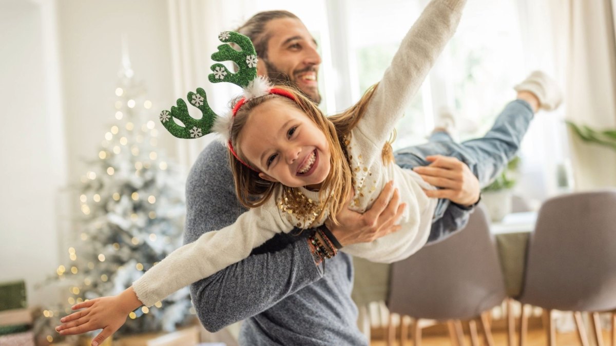 Junger Vater mit Tochter weihnachtlich