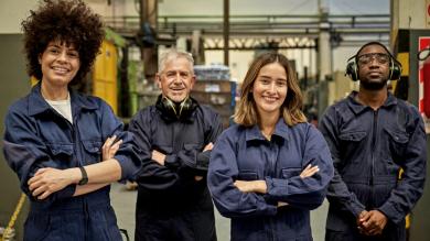 
		vier Personen im Blaumann posieren
	